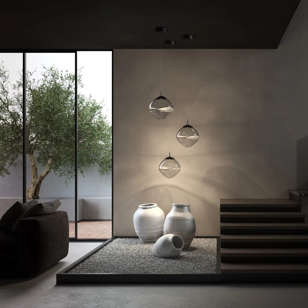 Lumina: Mehrere kleine schwebende Lichtkörper in einem hohen Betonraum mit Treppe und Ausblick in den Garten.